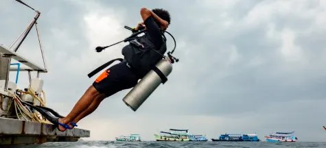 Diver back-rolling off the boat