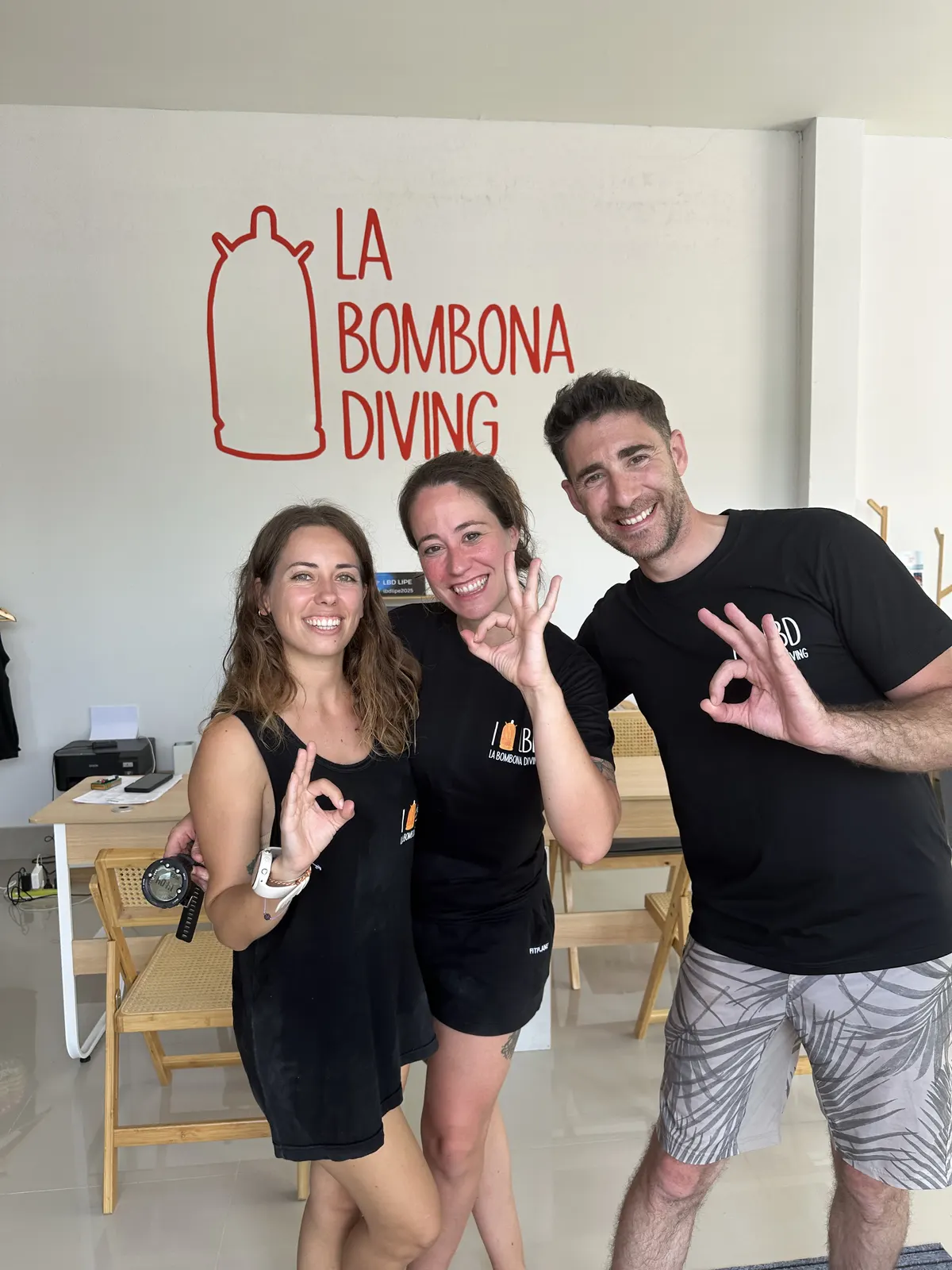 Newly certified divers giving the OK sign at La Bombona Diving