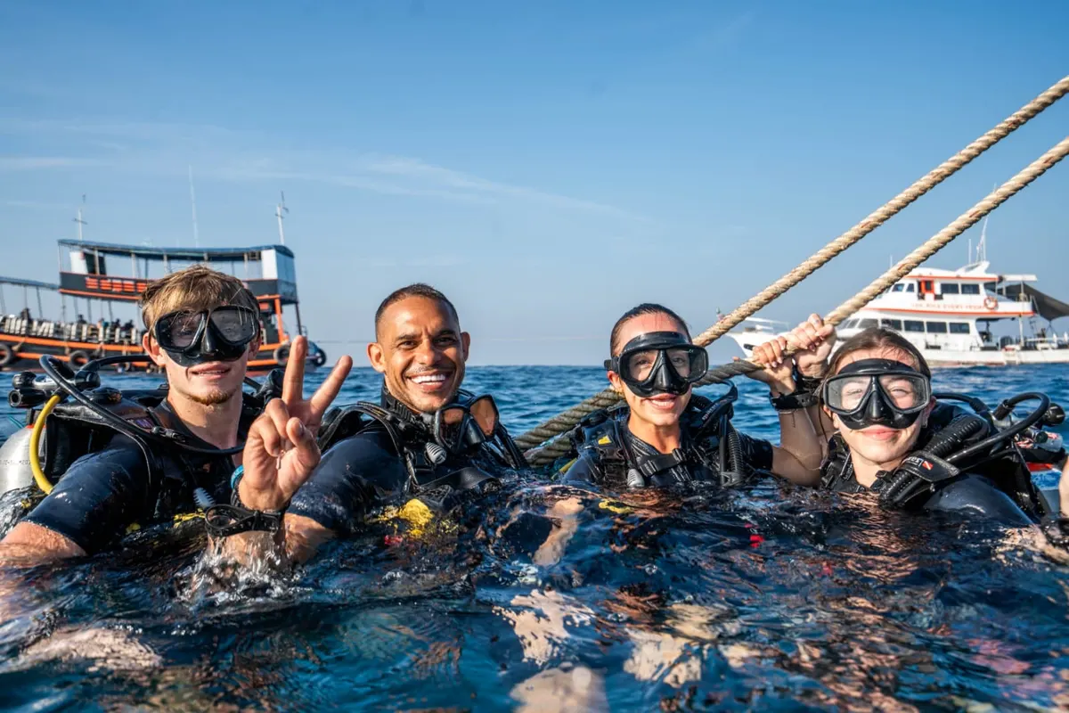Divemaster trainees at the surface beside the boat, ready to descend