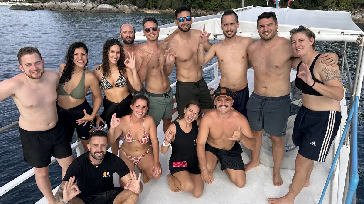 Newly certified advanced divers celebrating on the boat