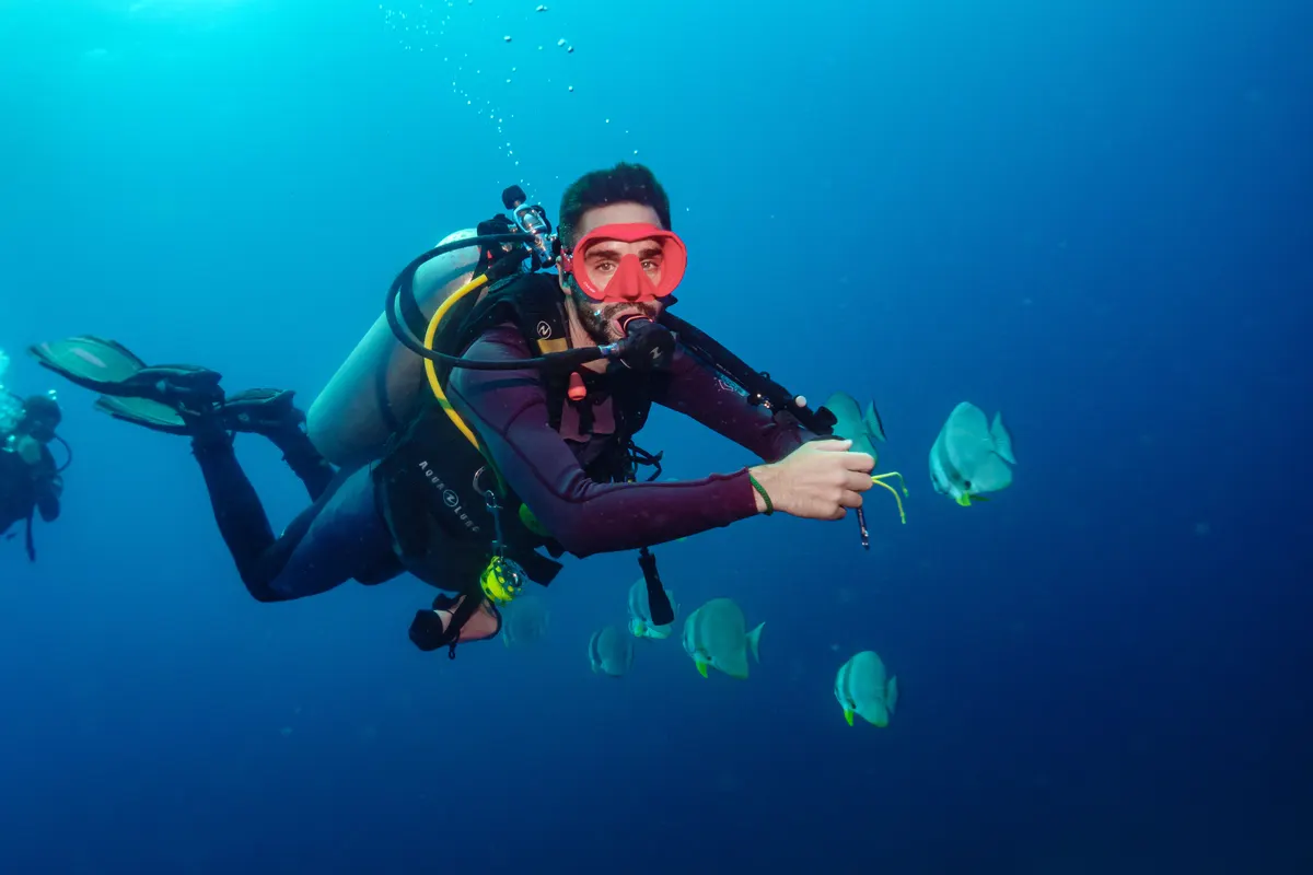 Diver running a search pattern in the blue waters of Koh Lipe