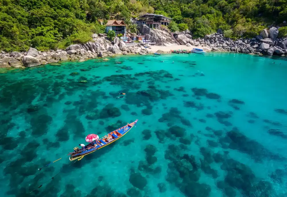 Mango Bay on the north coast of Koh Tao, a wide bay with calm turquoise water framed by green hills