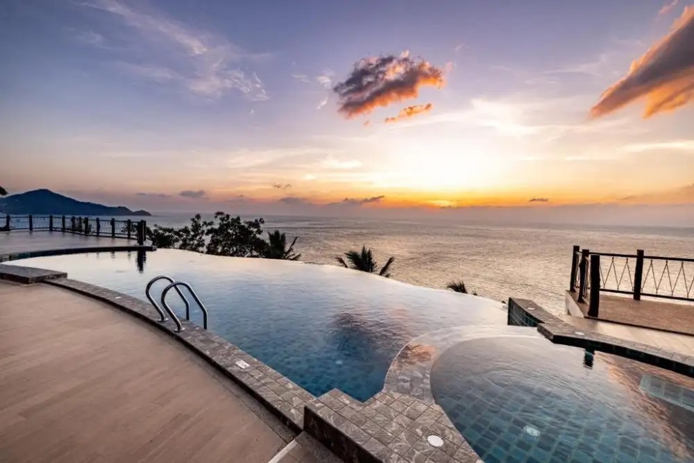 A resort swimming pool surrounded by palm trees on Koh Tao
