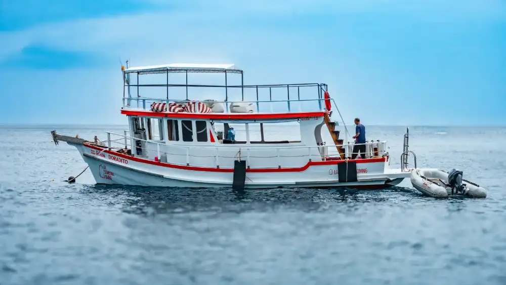 A dive boat crossing the calm blue waters of the Gulf of Thailand on the way to a Koh Tao dive site