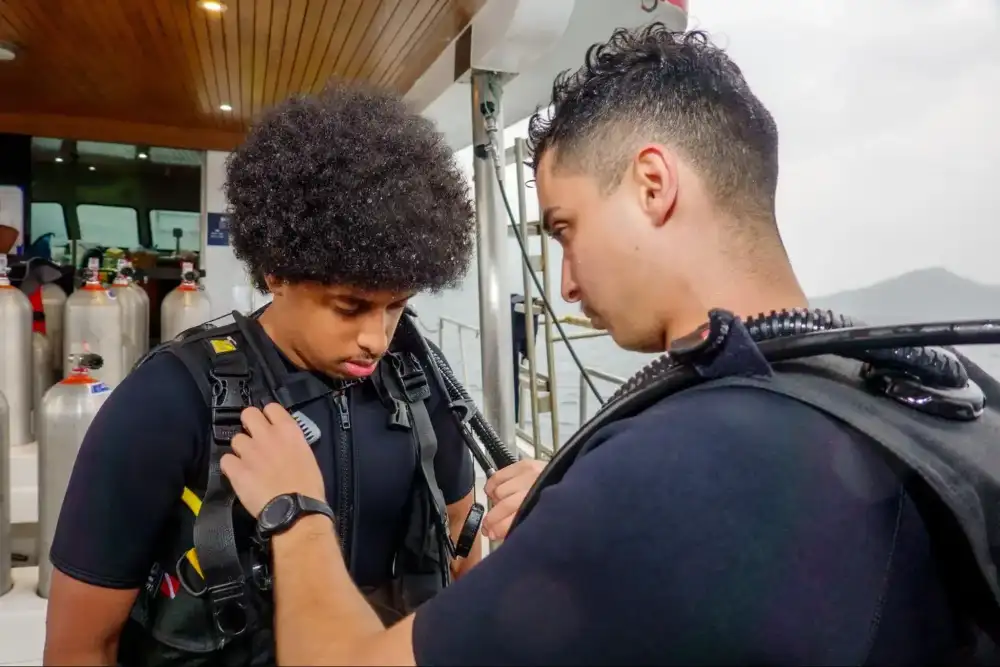 A diver checking their scuba gear on the boat before entering the water