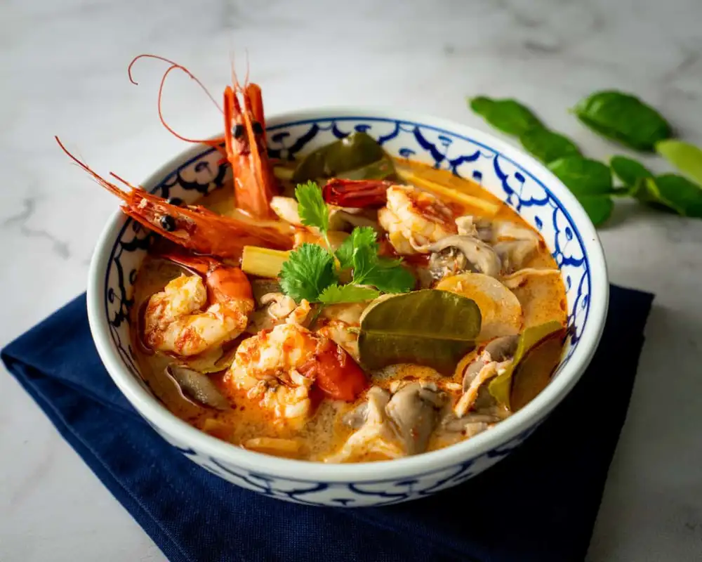 A bowl of Tom Yum Goong, Thai hot and sour shrimp soup with lemongrass, lime leaves and chili